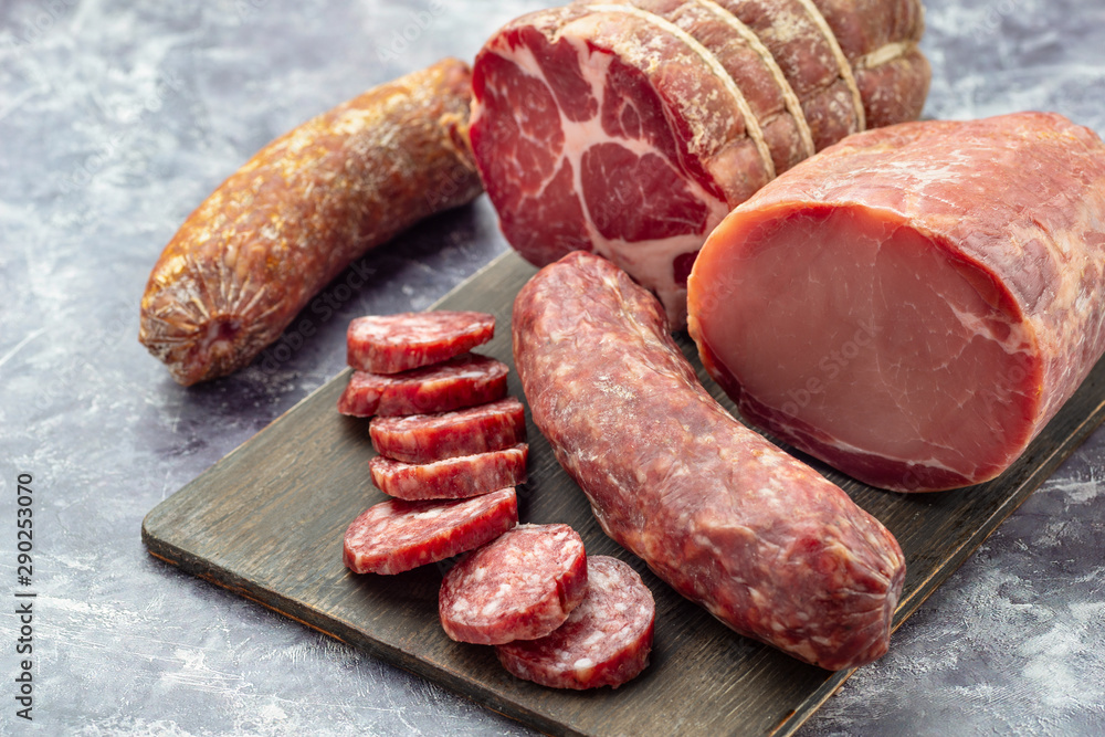 Assortment of delicious deli meats on wooden board Assortment of delicious deli meats on wooden board