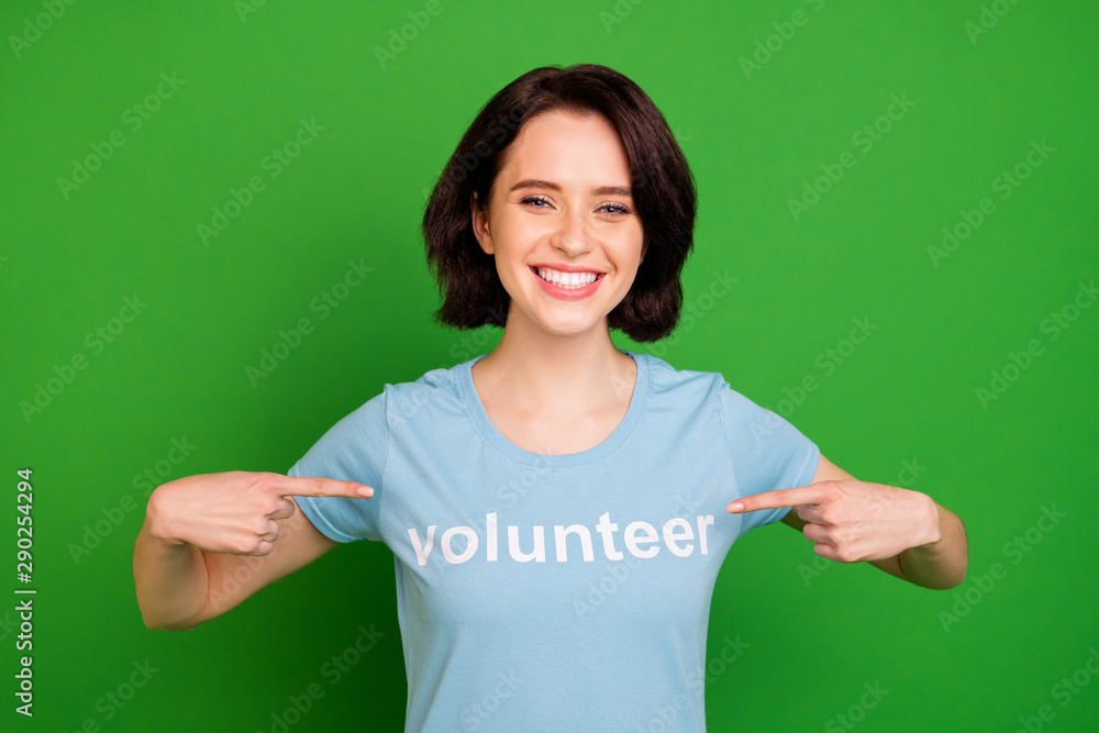 Fototapeta premium Close-up portrait of her she nice attractive lovely cheerful cheery girl wearing blue t-shirt pointing at herself volunteer organization isolated over bright vivid shine vibrant green background