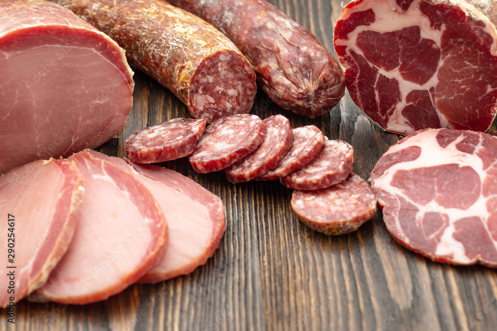 Antipasto platter cold meat with slices ham, beef jerky, salamon wooden board over rustic background Antipasto platter cold meat with slices ham, beef jerky, salamon wooden board over rustic background