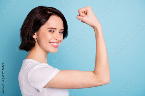 Close-up profile side view portrait of her she nice attractive lovely winsome cheerful cheery glad girl showing arm muscles isolated on bright vivid shine vibrant blue turquoise color background photo