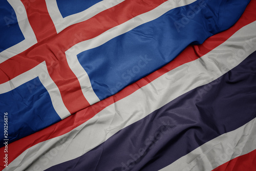 waving colorful flag of thailand and national flag of iceland.