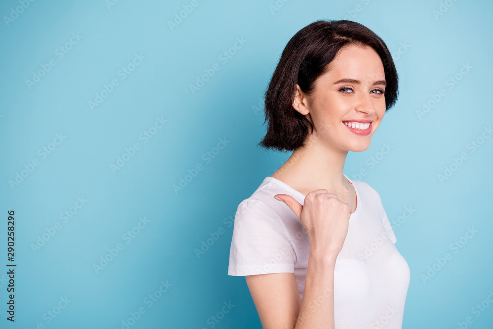 Close-up portrait of her she nice attractive lovely confident cheerful cheery girl pointing thumb back aside demonstrating advert isolated on bright vivid shine vibrant blue turquoise color background Close-up portrait of her she nice attractive lovely confident cheerful cheery girl pointing thumb back aside demonstrating advert isolated on bright vivid shine vibrant blue turquoise color background