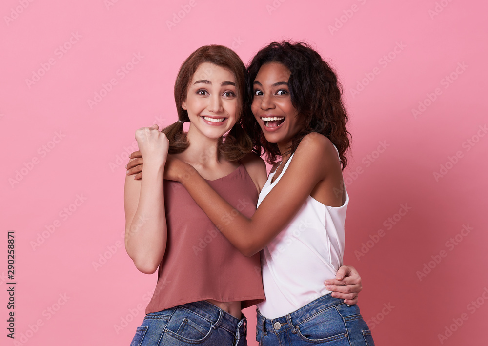 Portrait of two young woman happy and hug together over pink background. Portrait of two young woman happy and hug together over pink background.
