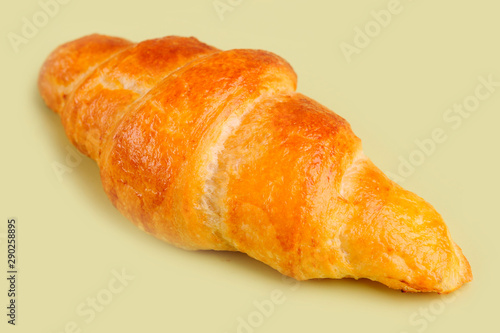 Croissant on yellow board.