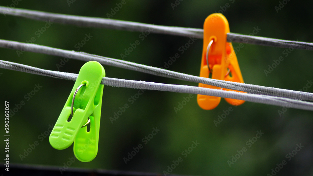 Green and orange clothespins on the rope Green and orange clothespins on the rope