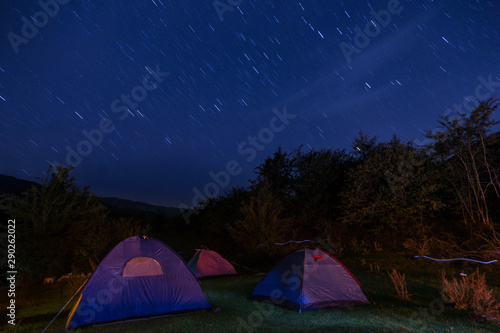 Night camping into the mountain, long exposure stars on the sky photo.