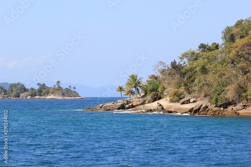 Island with green vegetation surrounded by blue ocean and clean sky. Region of Paraty, Brazil