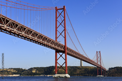 The April 25 Bridge links central Lisbon with the south bank of the Tagus River, the monument of Cristo Rei overlooks the river from a towering pedestal on the south bank, Portugal © hnphotography