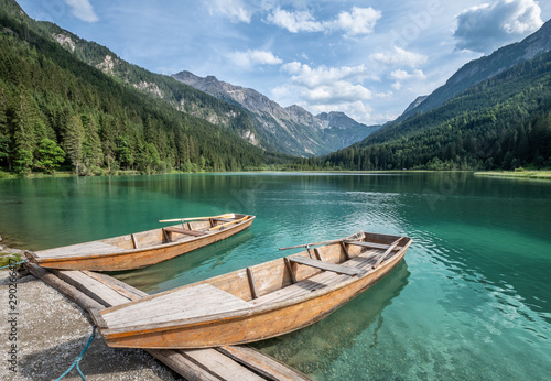 Fototapeta Naklejka Na Ścianę i Meble -  Scenic mountain landscape with turquoise lake and wooden boat at sunny summer day in Austria Alps