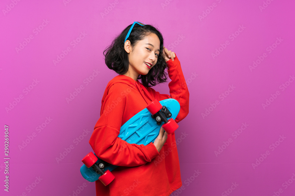 Asian young girl with skate over purple background Asian young girl with skate over purple background