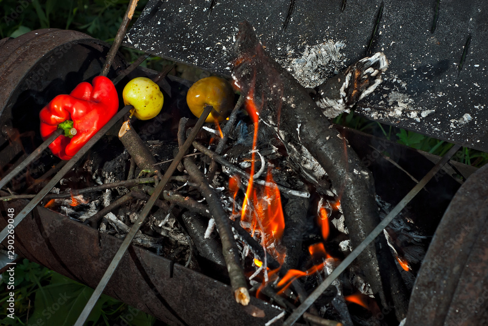 Grilled vegetables are baked on fire. The apples and peppers are roasting in the evening. Grilled vegetables are baked on fire. The apples and peppers are roasting in the evening.