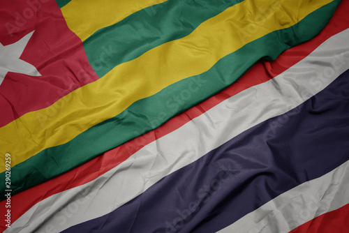 waving colorful flag of thailand and national flag of togo.