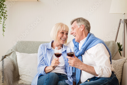 Loving mature couple drinking red wine, celebrating anniversary