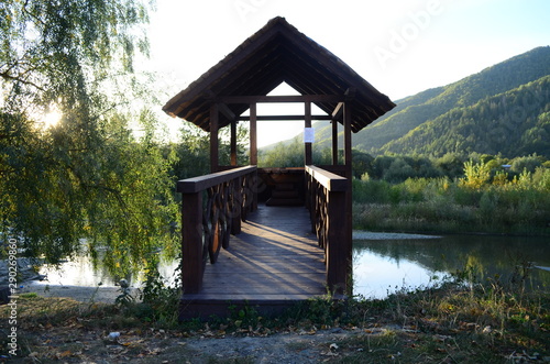 Wooden arbor on the river bank with a sunset view