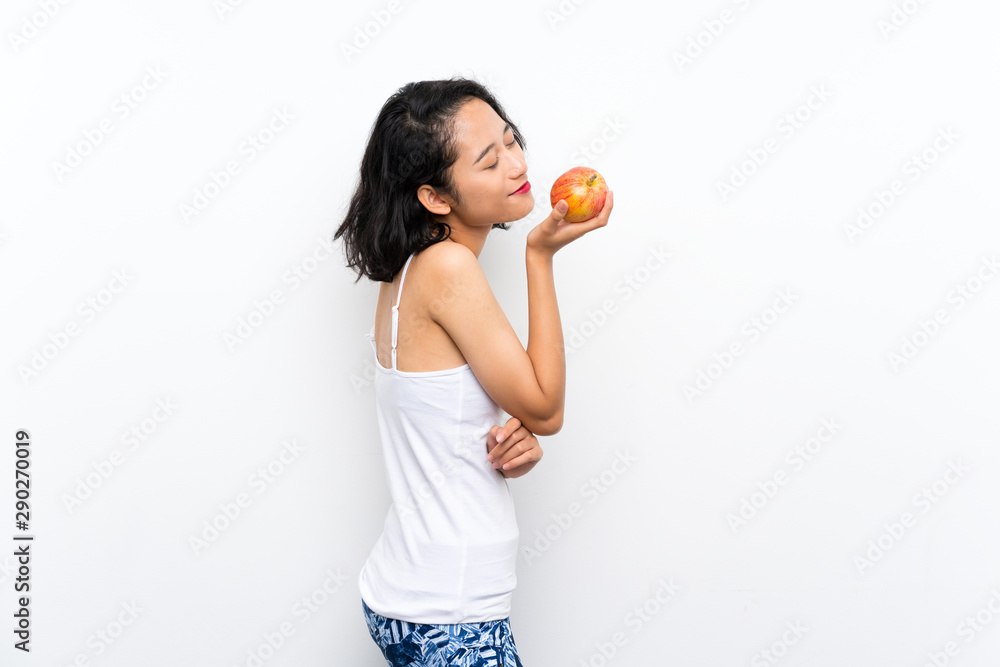 Asian young woman with an apple over isolated white background Asian young woman with an apple over isolated white background