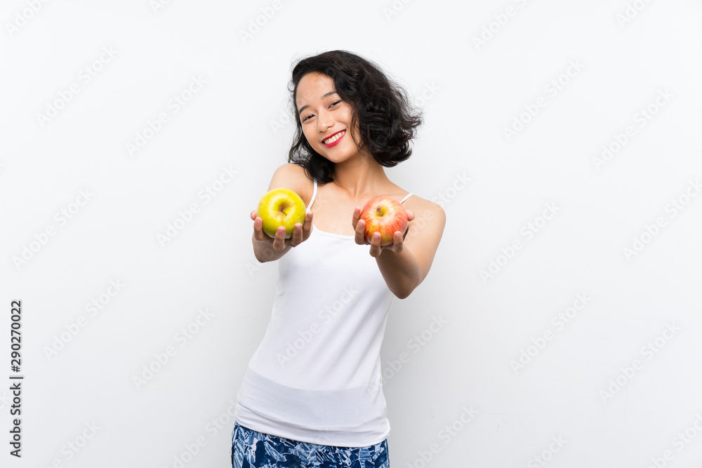 Asian young woman with an apple over isolated white background Asian young woman with an apple over isolated white background