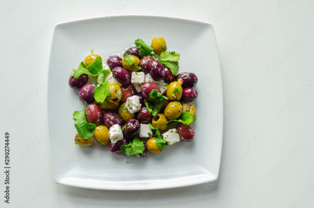 Fresh Greek salad based on green and black olives with pieces of white feta cheese and parsley Fresh Greek salad based on green and black olives with pieces of white feta cheese and parsley
