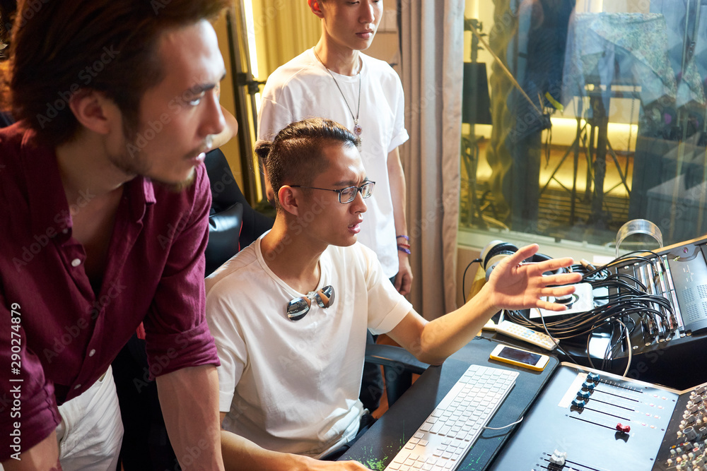 Obraz premium young asian musician editing music using computer