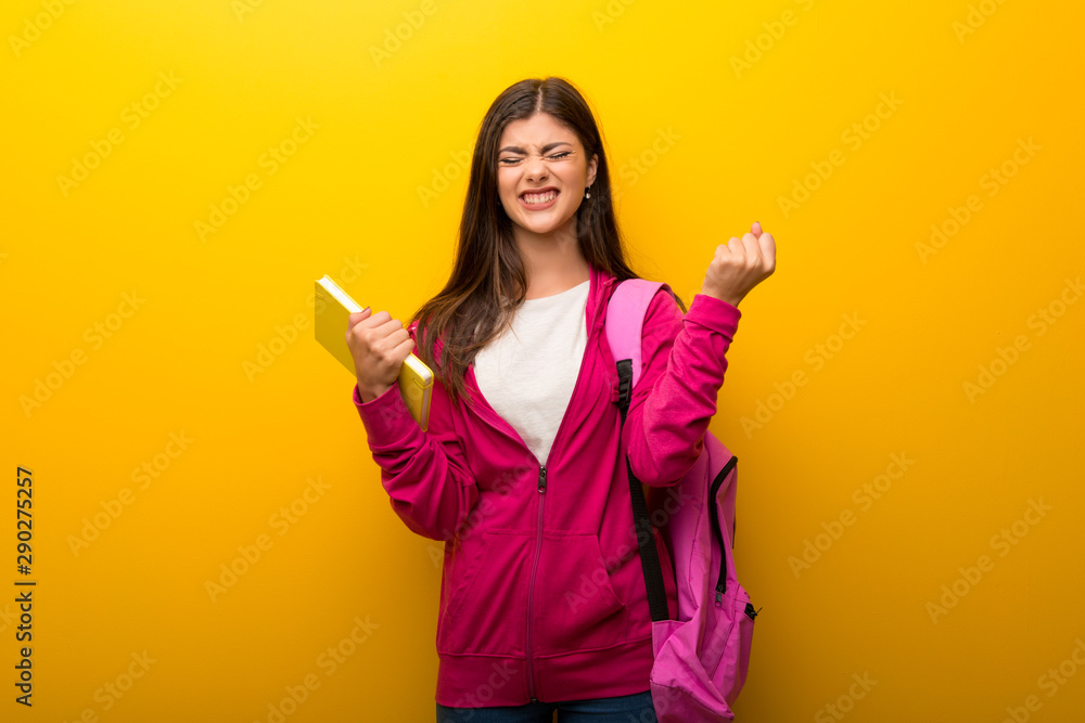 Teenager student girl on vibrant yellow background annoyed angry in furious gesture Teenager student girl on vibrant yellow background annoyed angry in furious gesture