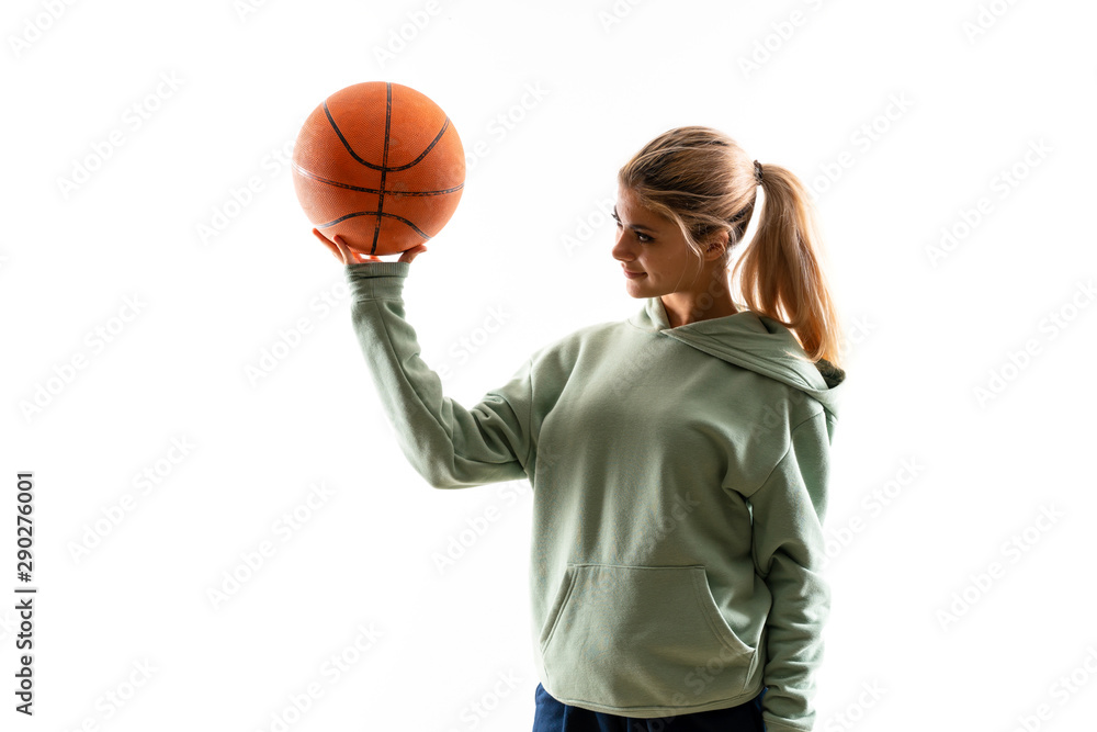 Teenager girl playing basketball over isolated white background