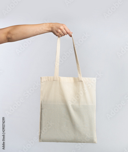 Hand Holding White Blank Eco Bag Over Studio Background