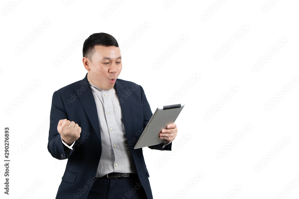 Portrait of an excited young Asian businessman holding digital tablet computer with fist hand, celebrating success isolated on white background with copy space. Technology, online marketing concept. Portrait of an excited young Asian businessman holding digital tablet computer with fist hand, celebrating success isolated on white background with copy space. Technology, online marketing concept.