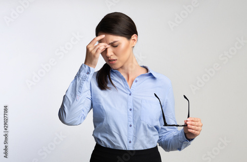 Overworked Businesswoman Massaging Nosebridge Having Ocular Hypertension Over White Background photo