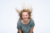 Cute curly blonde young model in studio with hair blown by wind