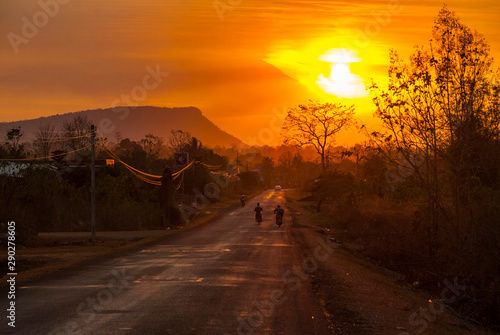 Motorbike driving on scenic road in sunset, Laos © dinozzaver