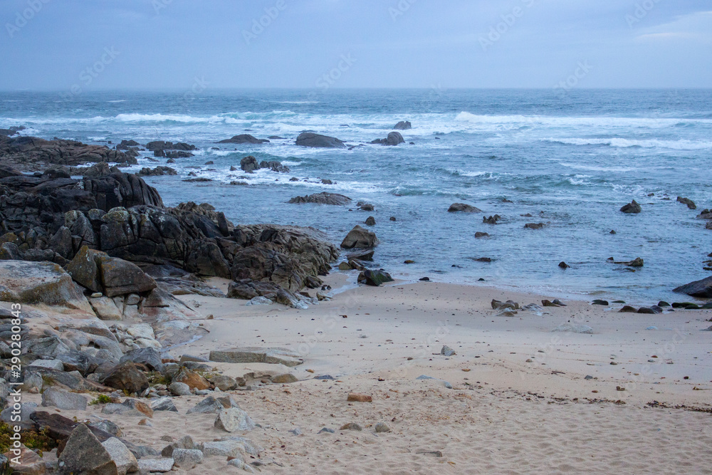 Atlantic Ocean coast in Portugal in the morning. Seascape in blue morning fog. Ocean beach with stones and waves. Empty beach. Rocky coastline. Calm ocean shore. Wild nature concept. Atlantic Ocean coast in Portugal in the morning. Seascape in blue morning fog. Ocean beach with stones and waves. Empty beach. Rocky coastline. Calm ocean shore. Wild nature concept.