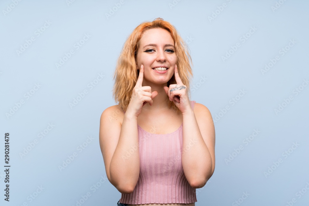 Young woman over isolated blue background smiling with a happy and pleasant expression Young woman over isolated blue background smiling with a happy and pleasant expression