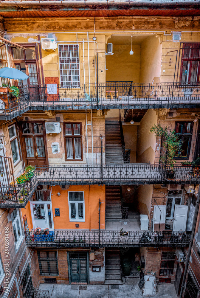 Budapest, Hungary -August 29, 2019: Staircase, forged railing and arched door in an old apartment building in Budapest, Hungary. Housing conditions in the old town quarter