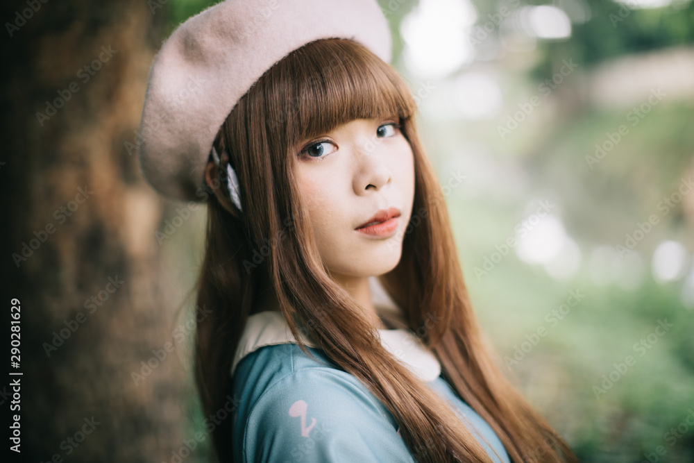 Naklejka premium Portrait of asian girl in lolita fashion dress in garden background