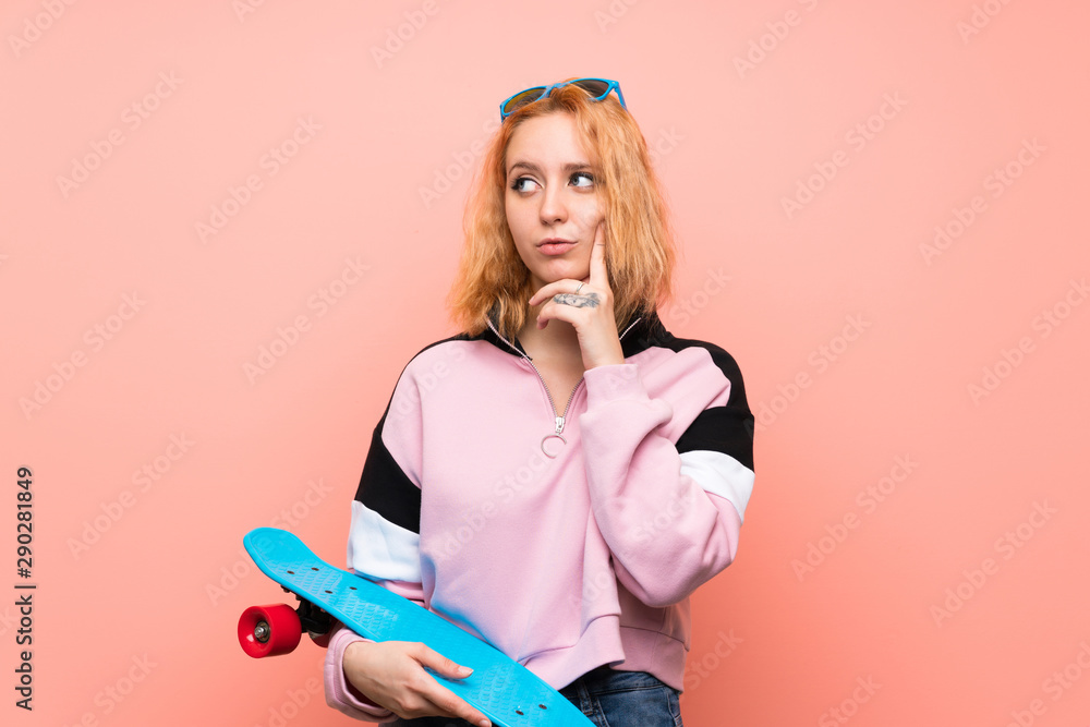 Naklejka premium Young skater woman over isolated pink background thinking an idea