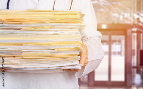 Close-up of a Doctor with Stack of Documents / Files