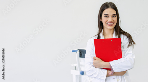 Beautiful female doctor holding clipboard smiling isolated on white background. Young happy smiling ophthalmologist holding folder with diagnosis. copy space
