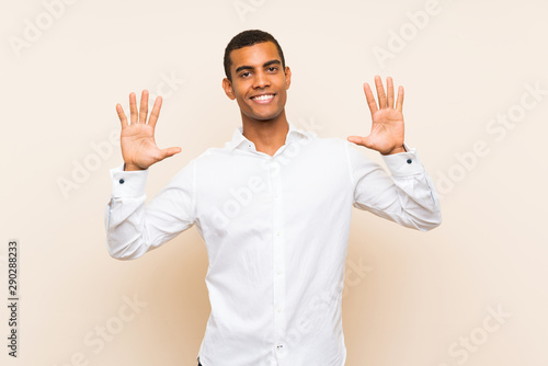 Young handsome brunette man over isolated background counting ten with fingers © luismolinero