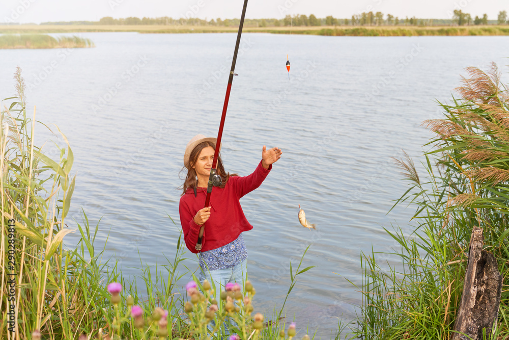 fishing with fishing rod standing on shore of lake fishing with fishing rod standing on shore of lake