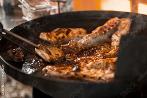 Process of meat cooking on big pan outdoor