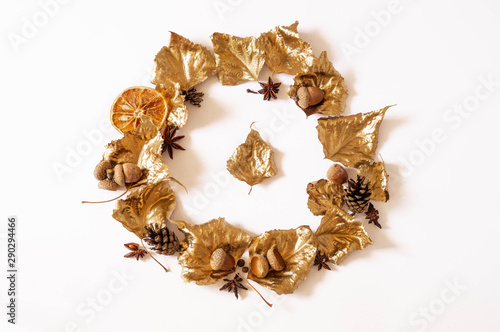 Autumn composition. Wreath made of gold leaves on white background. Fall concept