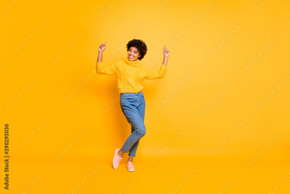 Full length body size photo of curly crazy funny overjoyed girlfriend dancing rejoicing wearing jeans denim sweater footwear isolated over yellow background vivid color Full length body size photo of curly crazy funny overjoyed girlfriend dancing rejoicing wearing jeans denim sweater footwear isolated over yellow background vivid color