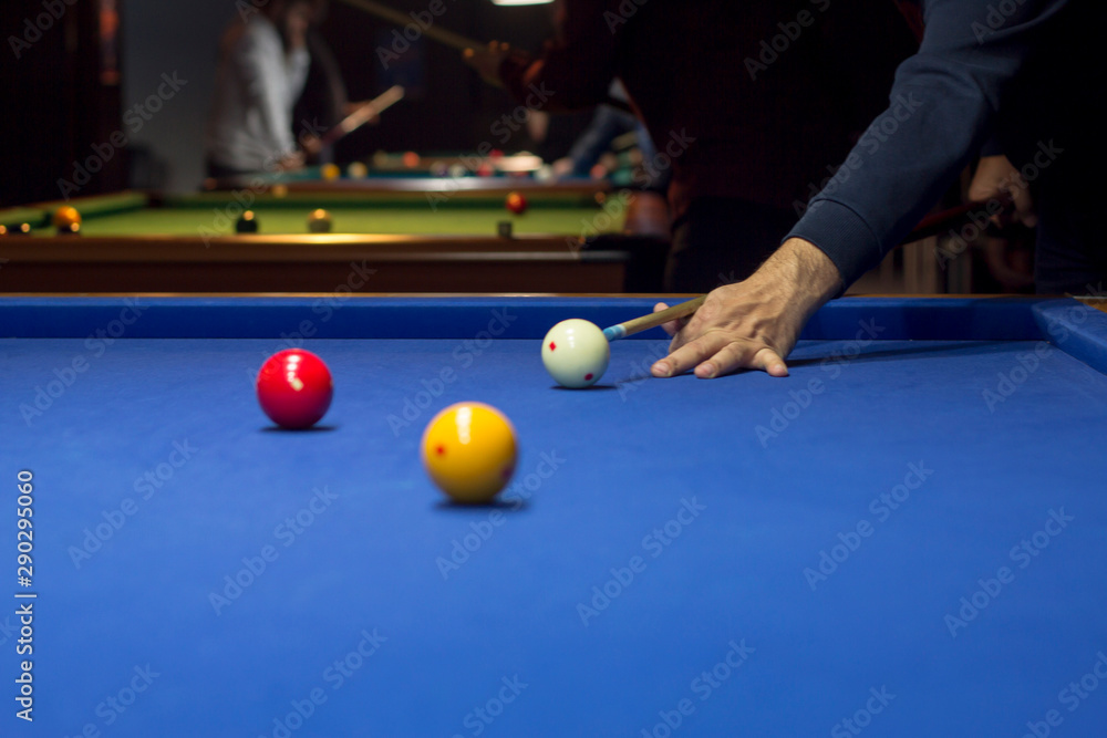 Fototapeta premium Unrecognizable man playing billiard taking aim