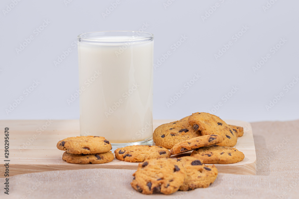 Cookies and fresh milk placed on a wooden plate on a white background, break snacks, chocolate chip cookies Cookies and fresh milk placed on a wooden plate on a white background, break snacks, chocolate chip cookies