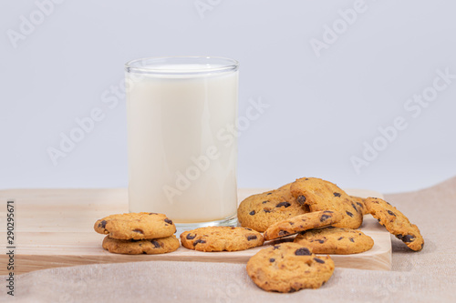 Cookies and fresh milk placed on a wooden plate on a white background, break snacks, chocolate chip cookies