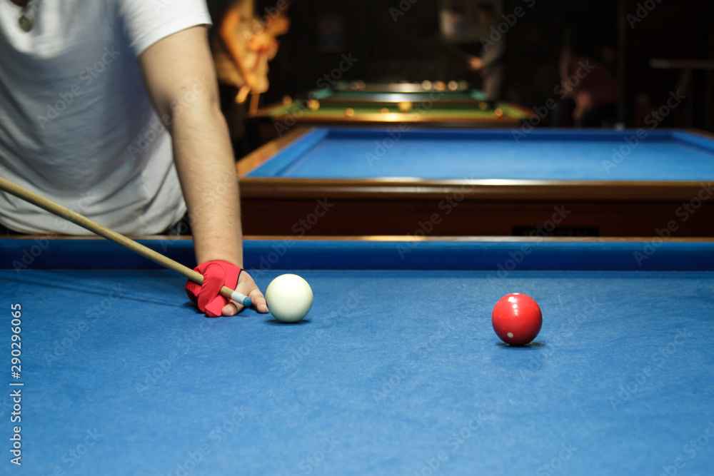 Fototapeta premium Unrecognizable man playing billiard taking aim