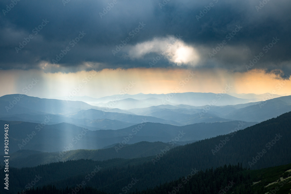 sun ray through thunderstorm clouds in the mountains