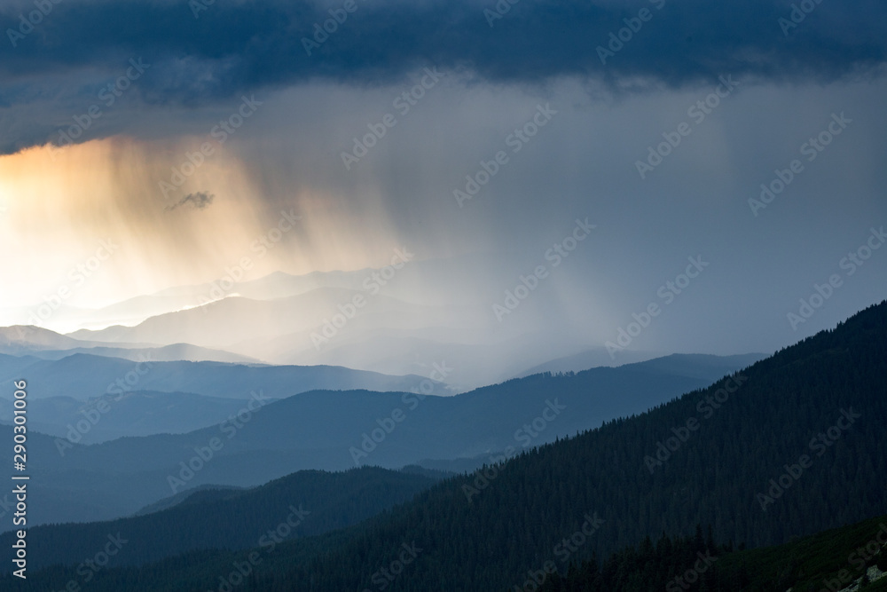 sun ray through thunderstorm clouds in the mountains