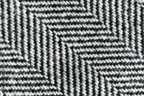 Herringbone tweed wool fabric texture background closeup. Natural organic wool cloth with classic pattern