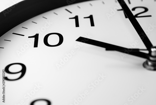 Close up of white analog clock hand with ten o'clock 