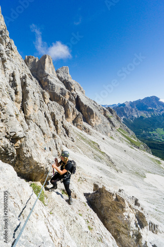 attractive blonde female mountain climber in the Dolomites of Italy